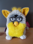 A Banana Peel Furby with silver eyes