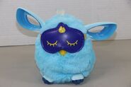 A blue Furby Connect with its sleep mask on