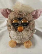 A Church Mouse Furby with severely sun-bleached facial features