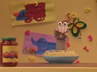 Oobi tries to "strum" and swing spaghetti...