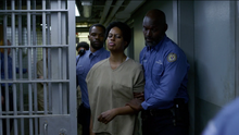Sophia being escorted out of her  cell after she set her bed on fire