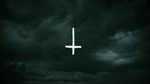 A dark and cloudy background with an inverted cross as seen in the second teaser trailer