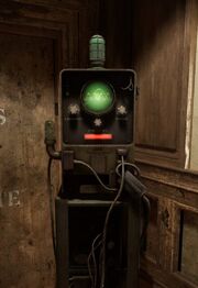 The image shows a tall box with a green circle screen and three knobs to turn the frequency line. The one that must be copied is in green, the one that requires change in red until it is identical to which is turns green and is completed. The three knobs are labelled: 1.AMPLITUDE 2.FREQUENCY 3.PHASE. There is also a red rectangle underneath the frequency knob and the text Zikk Communication. There is a unlit green bulb at the top and connected to the left side.