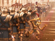 A brown minion takes a helmet from an imperial legionary.