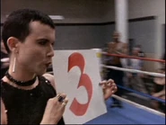 Kiki Faye Downing in the boxing-ring as “ring girl” in the match between Chucky Pancamo and Cyril O’Reily, after Pancamo has begun to show the ill effects of having been drugged by Ryan O’Reily