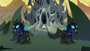 The Changeling guards outside the hive, unaware of Discord, Trixie, Starlight and Thorax