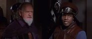 Panaka and Sio Bibble explaining to the Jedi the Trade Federation want the queen alive to sign a treaty to make their invasion legal.