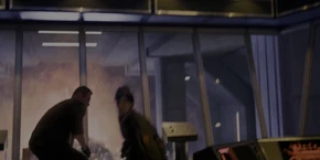 Joyce attempting to stop Grigori before he apprehends her.