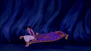 Aladdin and Abu nervously sitting on carpet.