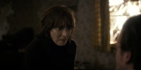 A stunned Joyce kneeling down when Hopper reveals he discovered Will's body to truly be a fake.