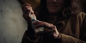 Joyce using a glue bottle as she prepares for Will's interrogation.