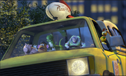 Hamm riding a Pizza Planet truck with Potato Head, Buzz, Rex and Slinky in Toy Story 2