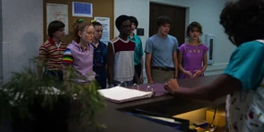 The kids and teens being told by the receptionist that only two visitors can visit a patient.