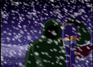 A hood-covered Red Star carrying an unconscious Starfire over his shoulder as he rescues her from a blizzard