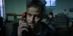 Joyce watching Antonov talk to an American contact of his on the phone.