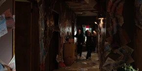 Joyce and Mike searching in the hallway.