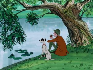 Roger and Pongo sitting by a pond.