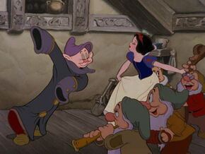 Doc playing an instrument as Snow White goes to dance with Dopey who's standing on top of Sneezy.