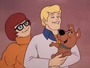 Fred and Velma smile and hold Scrappy thankful for his help.