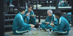 Il-nam, Ali, Sang-woo and Gi-hun eating EP3