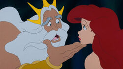 Ariel's chin being held by her concerned father.