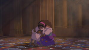Djali embraced by Esmeralda after she finishes her prayer.