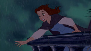 Belle still reaching for Beast's hand as he climbs his way up towards her.