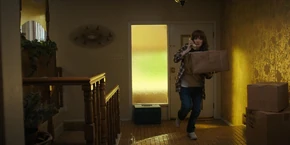 Joyce carrying a package she received from the postman.