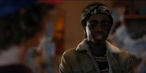 Lucas glancing at Dustin when he purrs to show off his new teeth.