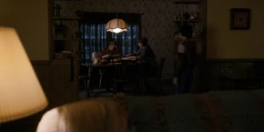 Joyce and Jonathan at the table as Will returns from the bathroom.