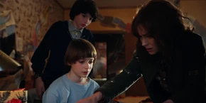 Joyce and Mike looking at Will's drawing of Hopper's location.