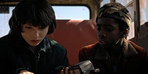 Lucas and Mike listening to Nancy's voice on the walkie.