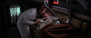 An injured Luke being aided by Leia.