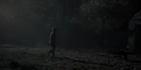 Joyce walking outside to get an axe from her shed.