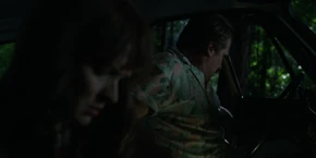 Upon getting in the car, Joyce hears Hopper ask where they need to go to next.