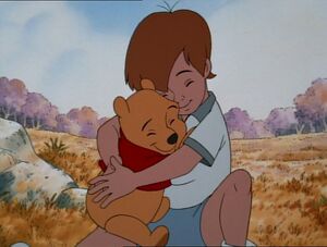 Pooh and Christopher Robin sharing a hug.