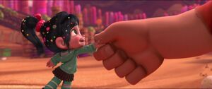 Vanellope shaking Ralph's hand, sealing their deal.