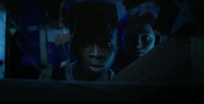 Lucas and Max looking through the boarded window.