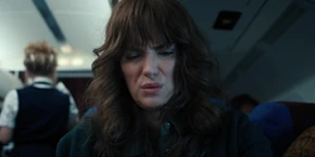 Joyce not happy with the meal she has to eat out of a box the stewardess gave her.