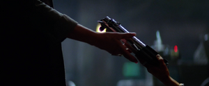 Maz Kanata hands Leia Organa Luke Skywalker's lightsaber shortly after the destruction of her castle by Captain Phasma and her First Order Stormtroopers.