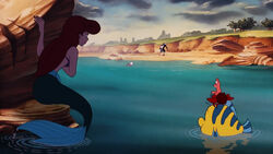 Ariel hiding next to a rock as she, Sebastian, and Flounder watch Eric leave with his butler.