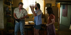 Joyce and Murray watching Hopper hang up the phone after finishing his call.