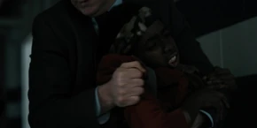 Lucas trying to free himself from the agent's grip.