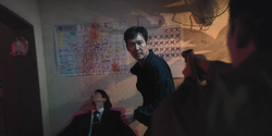 Squid Game 2 - Jun-ho pointing his gun at Gi-hun EP2