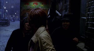Mary Jane being cornered by a group of men in an alleyway.