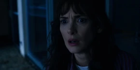 Joyce watching a man leave the lab's grounds, driving a motorcycle.