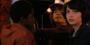 Lucas, Dustin, and Mike wondering who "MADMAX" is.