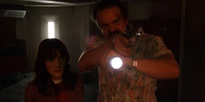 Joyce and Hopper seeing the men looking confused when the latter orders them to put their hands up.