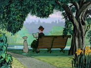 Anita and Perdita sitting on a bench at a park together.