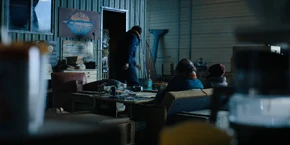 Joyce and Murray watching Yuri walk into his office.